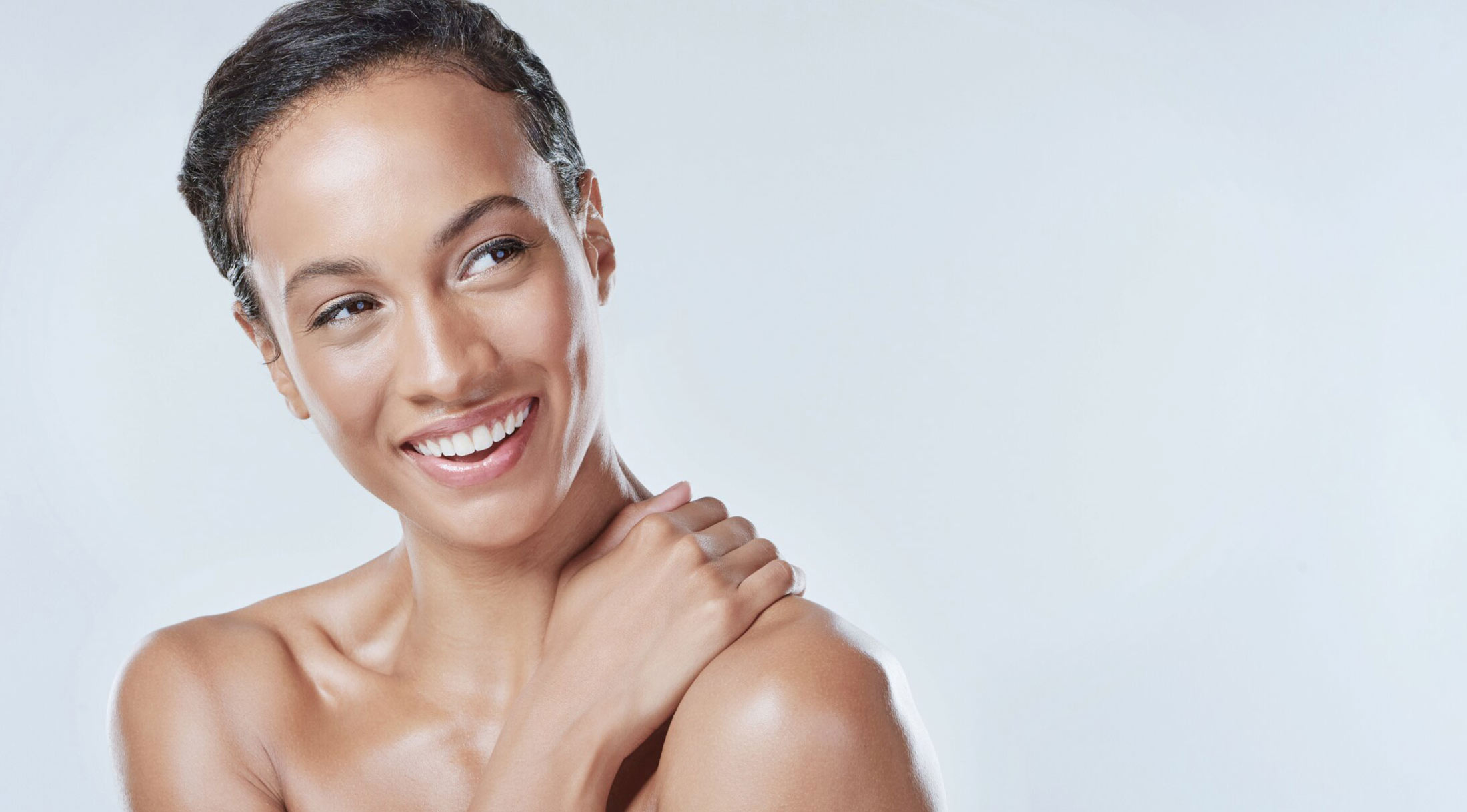 los angeles dental crowns patient model smiling and touching her shoulder